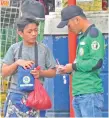  ??  ?? A traffic enforcer issues citation ticket to a boy who was caught jaywalking.