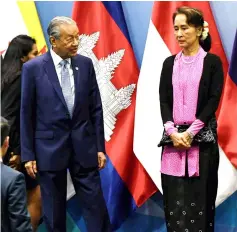  ??  ?? Dr Mahathir (left) and Suu Kyi arrive on stage for a group photo before the Asean-China summit on the sidelines of the 33rd Associatio­n of Southeast Asian Nations (Asean) summit in Singapore. — Bernama photo