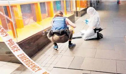  ?? ?? Police examine the scene of a Queen St jewellery store robbery on Saturday.