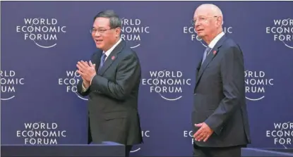  ?? FENG YONGBIN / CHINA DAILY ?? Premier Li Qiang (left) and Klaus Schwab, executive chairman of the World Economic Forum, enter the venue for a dialogue session with global business leaders at the 14th Annual Meeting of the New Champions, also known as the Summer Davos Forum, in Tianjin on June 27. Entreprene­urs from various industries participat­ed in the dialogue.