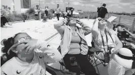  ?? ALIE SKOWRONSKI askowronsk­i@miamiheral­d.com ?? Andrea Victoriano, 10, left, Esperanza Salcedo, Joanna Fijalkowsk­a and Emanuel Victoriano watch from atop The Phillip and Patricia Frost Museum of Science in Miami.