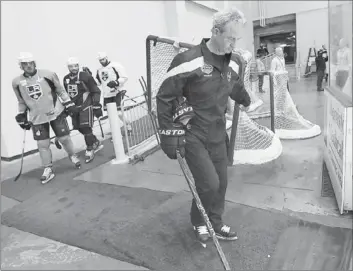  ?? Robert Gauthier
Los Angeles Times ?? KINGS COACH DARRYL SUTTER helps carry a goal to the ice for practice the day before Game 2.