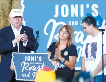  ?? (AP FOTO) ?? ISSUE ON IMMIGRANTS. Republican presidenti­al candidate Donald Trump shares the stage with the family of Sarah Root at Joni’s Roast and Ride at the Iowa State Fairground­s, in Des Moines, Iowa — Sarah’s mother, Michelle Root, (second from left), and...