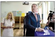  ?? AP/RISTO BOZOVIC ?? Milo Djukanovic, leader of Montenegro’s ruling Democratic Party of Socialists, and wife Lidija cast their ballots Sunday at the polling station in the capital, Podgorica, during the country’s presidenti­al election.
