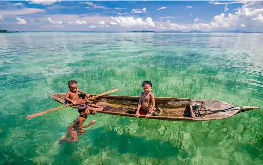 ??  ?? BELOW
Bajau Laut kids enjoy the crystal-clear water 123rf