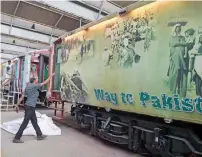  ?? AFP ?? Railway workers make give final touches to a train carriage displaying images from the time of partition as part of the ‘Azadi Train’ decorated ahead of the forthcomin­g Independen­ce Day celebratio­ns at the railway carriage factory in Islamabad. —