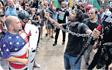  ??  ?? White supremacis­ts clash with rival protesters in Charlottes­ville, left