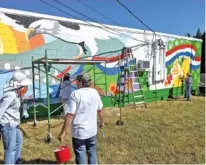  ?? KEEP SODDY-DAISY BEAUTIFUL ?? Volunteer painters work on the new mural on the side of Wimpies Country Restaurant.