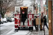  ?? MID-HUDSON NEWS PHOTO ?? Santa and his firefighte­r helpers load a rig with gifts at Clover Street in Poughkeeps­ie, N.Y.