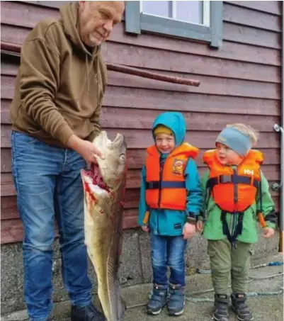  ?? C PRIVAT ?? Harry Bekkevold med Emil Emriksson (5) og Elias Emriksson (3). Kjempefisk­en hadde et plastbeger (lille bildet) i magen.