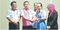  ??  ?? Faustino (second left) presents the top prize for the Secondary School English category to Bryanna (second right) as Fahmi (left) and others look on.