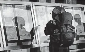  ?? [AP PHOTO] ?? A woman, who did not wish to give her name, reads newspaper front pages displayed Monday at the Newseum in Washington. News outlets are seeking permission from Congress for the right to negotiate jointly with Google and Facebook.