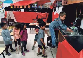  ?? RONALD W. ERDRICH/ABILENE REPORTER-NEWS ?? Children wash hands before lunch at a day care held at Martinez Elementary School in Abilene, Texas, last month.