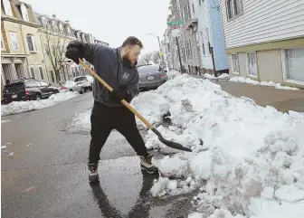  ??  ?? MARKING THE SPOT: Brandon Ross, digging out a space on O Street, had blunt words for Mayor Martin J. Walsh’s possible ban on space savers: `Tell him to come shovel my spot then.’