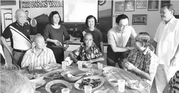  ??  ?? Chin (second right) distribute­s ‘ang pow’ to the elderly folks.