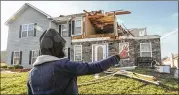  ??  ?? Khadijah Muhammad looks at her family’s residence on Jumpers Trail after a powerful overnight storm hit and damaged a number of houses.