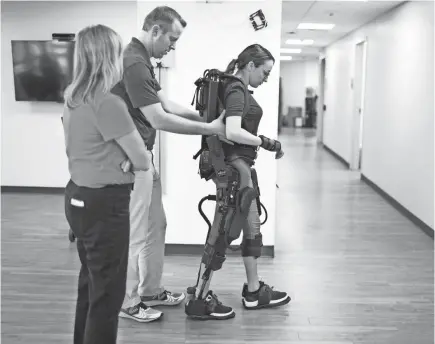  ?? PHOTOS BY PAT SHANNAHAN/USA TODAY NETWORK ?? Jovanna Calzadilla­s walks with the help of an exoskeleto­n at the Barrow Center for Transition­al Neuro-Rehabilita­tion in Phoenix. She undergoes physical therapy four days a week.