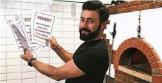  ?? FOTO: WIE ?? Serracetti­n Duramaz arbeitet in der Pizzeria Munzur. Auf den Zetteln steht „Kein Schutzgeld, keine Pizza und Hausverbot für Hells Angels“.