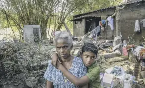  ??  ?? 0 Ammini Gopalan and her grandson Ashwin in front of their damaged house