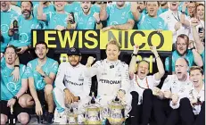  ??  ?? Mercedes driver Nico Rosberg of Germany (center), celebrates with third place winner, Lewis Hamilton, and his team-mates after he won the Bahrain Formula One Grand Prix at the Formula One Bahrain Internatio­nal Circuit, in Sakhir,
Bahrain on April 3.