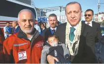  ?? AFP-Yonhap ?? This handout picture taken and released by the Turkish Presidenti­al Press Service Sunday in Hatay shows Head of the Turkish Red Crescent, Kerem Kinik, left, and Turkish President Recep Tayyip Erdogan, right, holding Syrian infant Karim Abdel Rahman,...