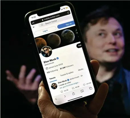  ?? GETTy imAgES ?? ALL ABOUT ME: A photo illustrati­on shows Elon Musk behind a phone screen displaying his Twitter account.