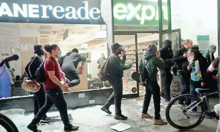  ?? — AFP ?? People loot a store during demonstrat­ions over the death of George Floyd by a Minneapoli­s police officer, in New York.