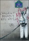  ?? GETTY IMAGES ?? An employee cleans a wall of graffiti after the “yellow vest” riot on the Champs-Elysees on Sunday in Paris.