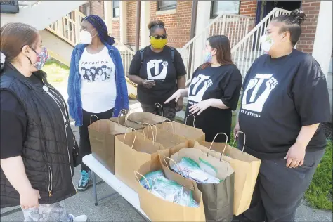  ?? Ned Gerard / Hearst Connecticu­t Media ?? Members of PT Partners, a group of resident volunteers at the P.T. Barnum Apartments, meet after receiving hundreds of hand-sewn protective masks in Bridgeport on Friday.
