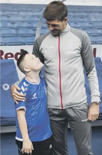  ??  ?? 0 Rangers manager Steven Gerrard with 11-year-old Dylan Ferguson at Ibrox yesterday.