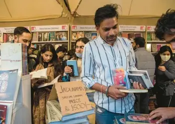  ?? ?? Attendees browse a book stall during Jashn-e-Rekhta, an Urdu poetry festival in New Delhi on Dec. 3. The festival, which was in its seventh edition, is part of a decade-old effort to bridge the gap between the language’s wide emotional connection and its receding accessibil­ity.