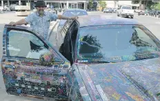  ?? MATTHEW OLSON ?? Jeff Janzen hangs out in front of the Bessboroug­h Hotel with his ‘Signature Series’ Crown Victoria, which features an estimated 6,500 signatures as well as other writings.