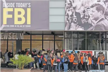  ?? Photo: Xinhua/Yin Bogu ?? Visitors line under a poster of former US President John F Kennedy to enter the Newseum in Washington DC, the United States, on October 26, 2017.