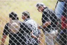  ?? AP ?? A man is detained after breaching border fencing separating San Diego, US, from Mexico. Under President Trump’s plan 22km of fence in San Diego will be replaced by a wall.