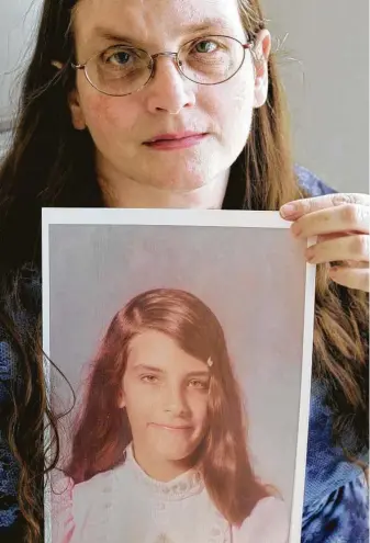  ?? Donna McWilliam / Associated Press ?? In this 2007 photo, Debbie Vasquez holds a photograph of herself at age 14, when she says she was first molested by a pastor of her church in Sanger.