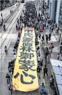  ?? REUTERS ?? People march with a banner to protest against what they say is the abuse of pro-democracy protesters by Hong Kong police, near Chater Garden in Central district, Hong Kong, China October 18, 2019.