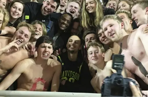  ?? Associated Press ?? Stephen Curry, center, poses with the Davidson College swim team at a basketball game at his alma mater Friday. The Golden State star is back in his hometown of Charlotte, N.C., this weekend for the NBA All-Star game.
