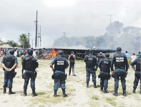  ?? Efe / geraldo maia ?? Policías brasileños vigilaban mientras ciudadanos brasileños se manifestab­an contra la presencia de inmigrante­s venezolano­s el sábado en Pacaraima.