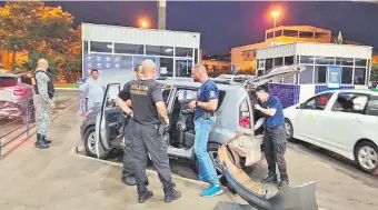  ?? ?? Agentes de la Policía Federal, Força Nacional y Receita Federal, con el auto del policía paraguayo.