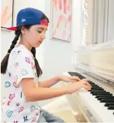  ??  ?? Michelle Rasul plays piano in the lobby of her apartment building. — IC