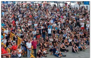  ?? AP/SIMONE ARVEDA ?? A crowd gathers Saturday outside the exhibition center in Genoa, Italy, where a giant screen showed the funeral service for some of the victims of last week’s bridge collapse.