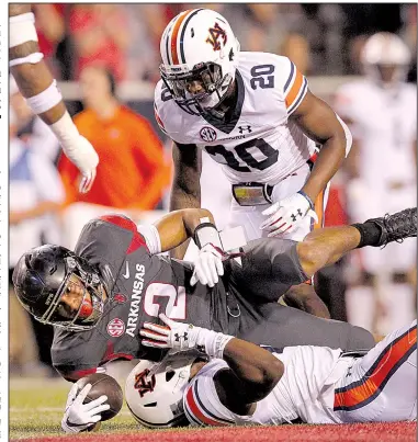  ?? Arkansas Democrat-Gazette/BENJAMIN KRAIN ?? Arkansas running back Chase Hayden (2) is tackled by Auburn defenders Jeremiah Dinson and Daniel Thomas during the second quarter of Saturday night’s game at Reynolds Razorback Stadium in Fayettevil­le. The No. 21-ranked Tigers defeated the Razorbacks...