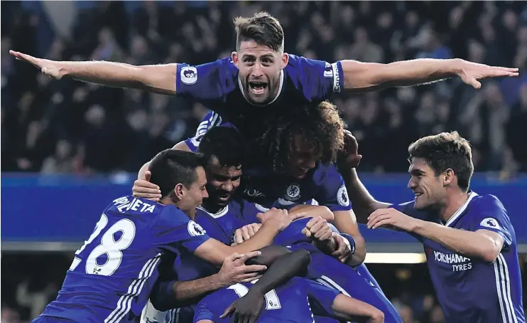  ?? — GETTY IMAGES ?? Chelsea defender Gary Cahill jumps onto the huddle after midfielder N’Golo Kante scored the team’s fourth goal in a 4-0 win over Manchester United on Sunday.