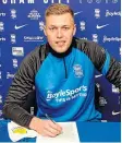  ??  ?? Sam Cosgrove puts pen to paper for Birmingham.