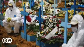  ??  ?? Cemetery workers are forced to don protective clothing during a funeral service in the state of Manaus