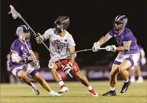  ?? Premier Lacrosse League / Contribute­d photo ?? New Fairfield’s CJ Costabile (9) of the Chaos splits a pair of opponents during a Premier Lacrosse League game against the Waterdogs on June 24.