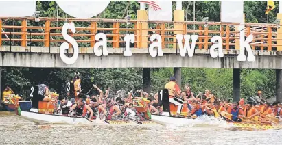  ??  ?? SENGIT: Sebahagian daripada aksi menarik perlumbaan Regata Perahu Naga Antarabang­sa Sarawak 2014 di Tebingan Kuching.