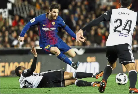  ??  ?? Unstoppabl­e: Barcelona’s Lionel Messi avoiding a tackle from Valencia’s Francis Coquelin in the Spanish King’s Cup semi-final secondleg match at the Mestalla on Thursday. — AP