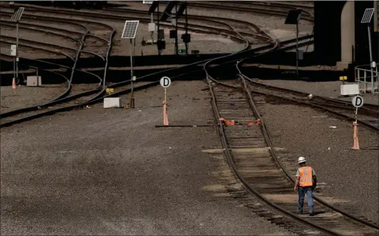  ?? CHARLIE RIEDEL, FILE — THE ASSOCIATED PRESS ?? A worker walks along tracks at a BNSF rail yard, Wednesday, Sept. 14, 2022, in Kansas City, Kan. On Monday, Nov. 14, 2022, a third railroad union has rejected its agreement with the nation’s freight railroads, increasing the chances that Congress may be called upon to settle the dispute and block a strike.