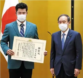  ?? — AP ?? Japan’s pride: Golfer hideki Matsuyama (left) poses with the PM’s Certificat­e he recieved from Prime Minister yoshihide suga (right) in Tokyo on april 30 after winning the us Masters.